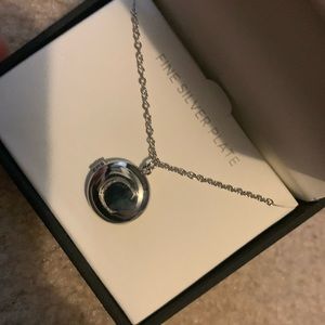 Brand new, never taken out of the box, silver plated locket with an engraved C.